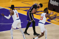 Los Angeles Lakers forward Anthony Davis, center, reacts after getting hit in the face by New York Knicks center Nerlens Noel (3) during the fourth quarter of an NBA basketball game Tuesday, May 11, 2021, in Los Angeles. New York Knicks forward Reggie Bullock (25) is at right. (AP Photo/Ashley Landis)