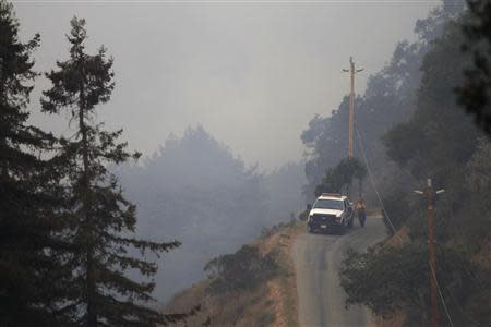 A firefighter walks along the access road to Pfeiffer Ridge during a wildfire in Big Sur, California, December 18, 2013. REUTERS/Michael Fiala