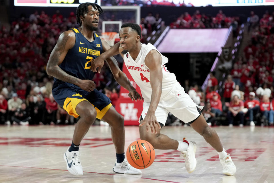 Houston guard L.J. Cryer (4) dribbles past West Virginia guard Kobe Johnson during the second half of an NCAA college basketball game Saturday Jan. 6, 2024, in Houston. (AP Photo/Eric Christian Smith)