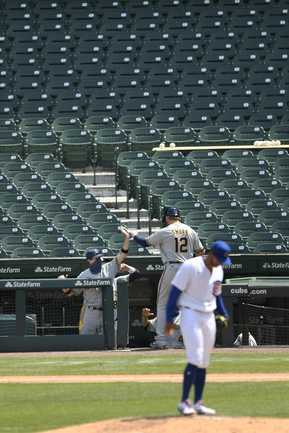 Milwaukee Brewers manager Craig Counsell left, celebrates with Justin Smoak (12) at the dugout after he hit a solo home run during the fifth inning of a baseball game against the Chicago Cubs Saturday, July 25, 2020, in Chicago. (AP Photo/Paul Beaty)