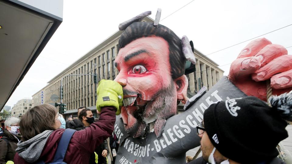 Mitarbeiterinnen und Mitarbeiter von Galeria Kaufhof schlagen am Tag der Schließung ihrer Filiale mit Boxhandschuhen auf eine Pappfigur von Firmeneigner Rene Benko ein.