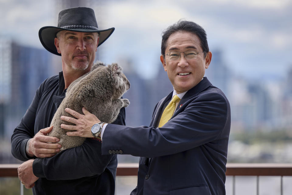 Japan's Prime Minister Fumio Kishida poses for a photo with a koala during a visit to Kings Park in Perth, Australia, Saturday, Oct. 22, 2022. Kishida is on a visit to bolster military and energy cooperation between Australia and Japan amid their shared concerns about China. (Stefan Gosatti/Pool Photo via AP)