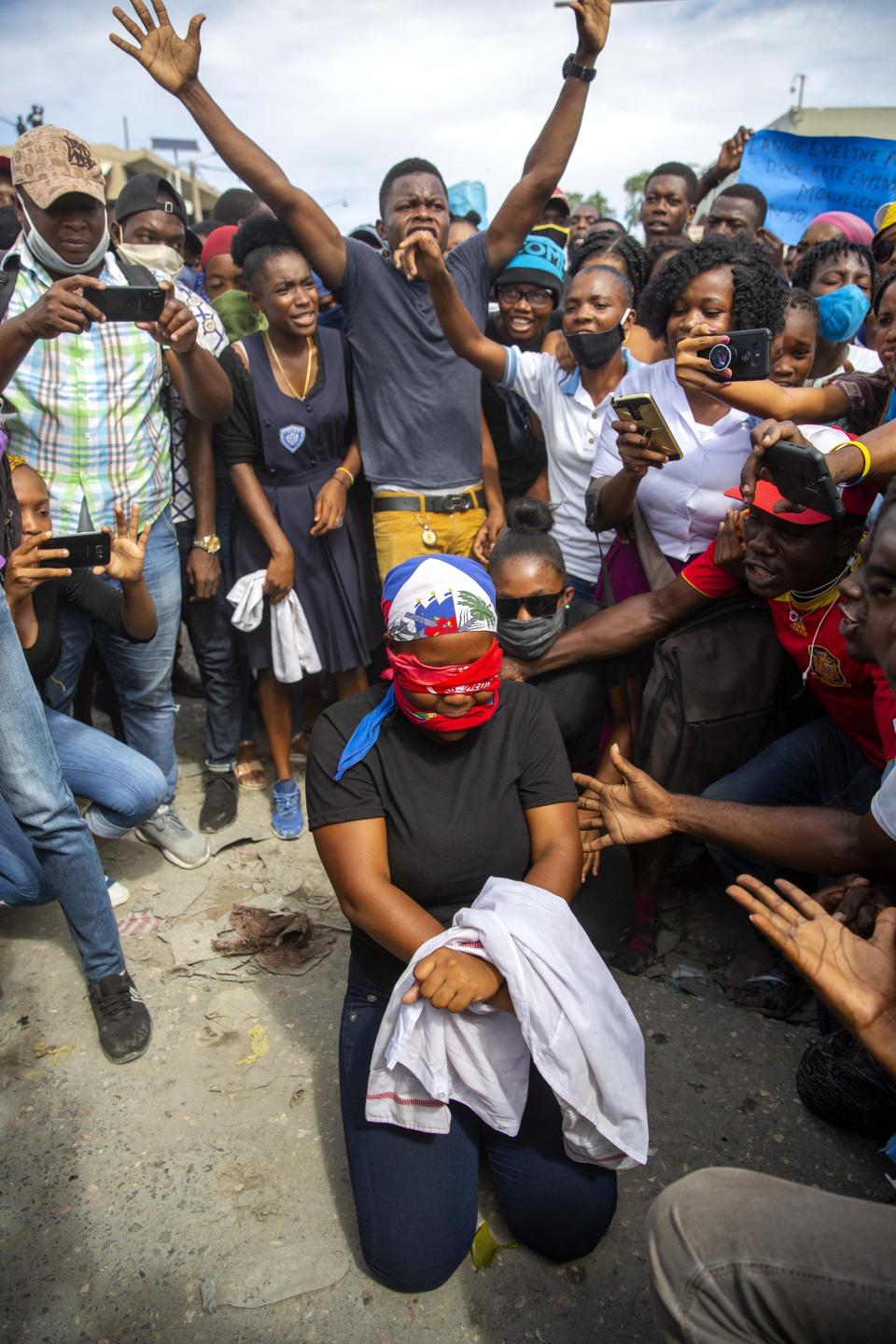 FILE - In this Nov. 5, 2020 file photo, a protester acts out the kidnapping of high school senior Evelyne Sincere, in Port-au-Prince, Haiti. The young woman was found in a trash heap after relatives said they were unable to pay the large ransom demanded by her captors. (AP Photo/Dieu Nalio Chery, File)