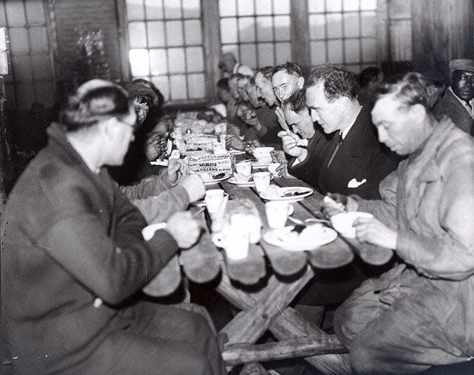 Detroit Mayor Frank Murphy, second on right, dines with unemployed men at a soup kitchen in 1932 during the Depression.