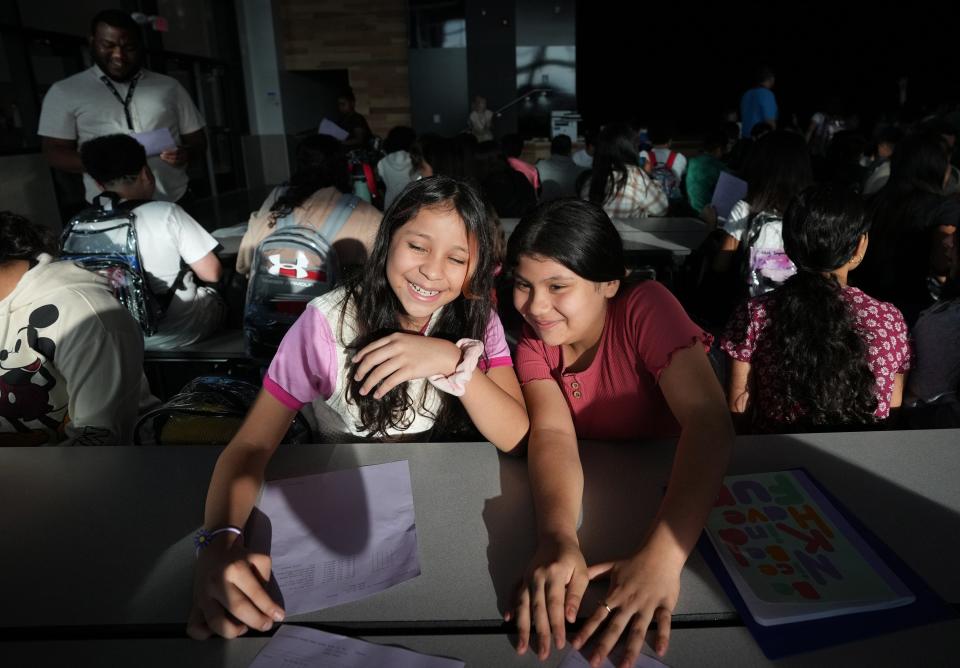 Sixth graders Alexia Argueta, left, and Estrella Cabrera share a happy moment as they arrive for the first day of classes at Del Valle Middle School on Wednesday.