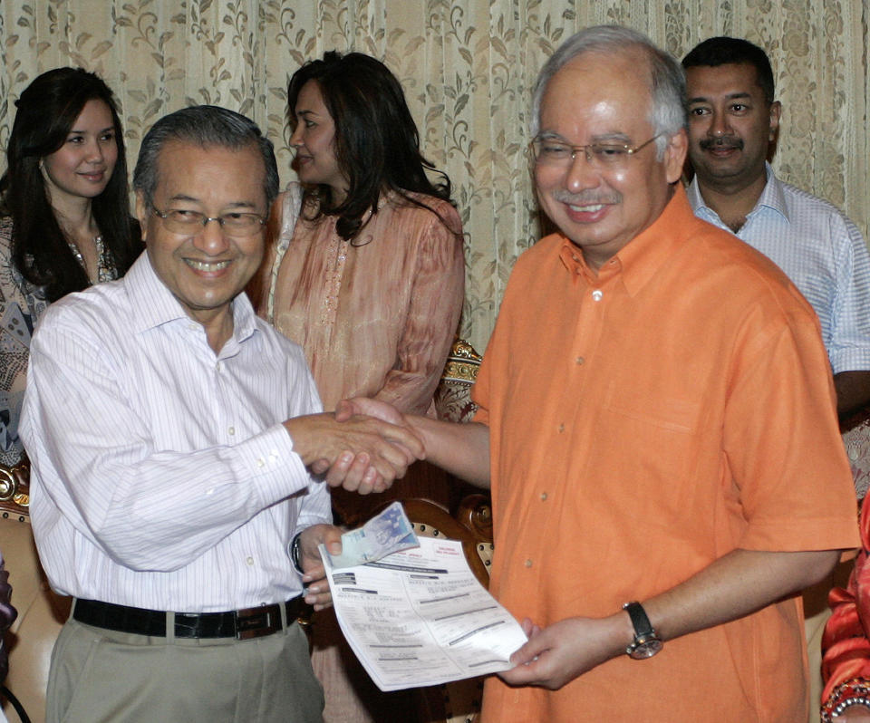 FILE - Malaysian new Prime Minister Najib Razak, right, receives the party form from former Prime Minister Mahathir Mohamad in Putrajaya, outside Kuala Lumpur, Malaysia, April 4, 2009. Najib Razak on Tuesday, Aug. 23, 2022 was Malaysia’s first former prime minister to go to prison -- a mighty fall for a veteran British-educated politician whose father and uncle were the country’s second and third prime ministers, respectively. The 1MDB financial scandal that brought him down was not just a personal blow but shook the stranglehold his United Malays National Organization party had over Malaysian politics. (AP Photo/Lai Seng Sin, file)