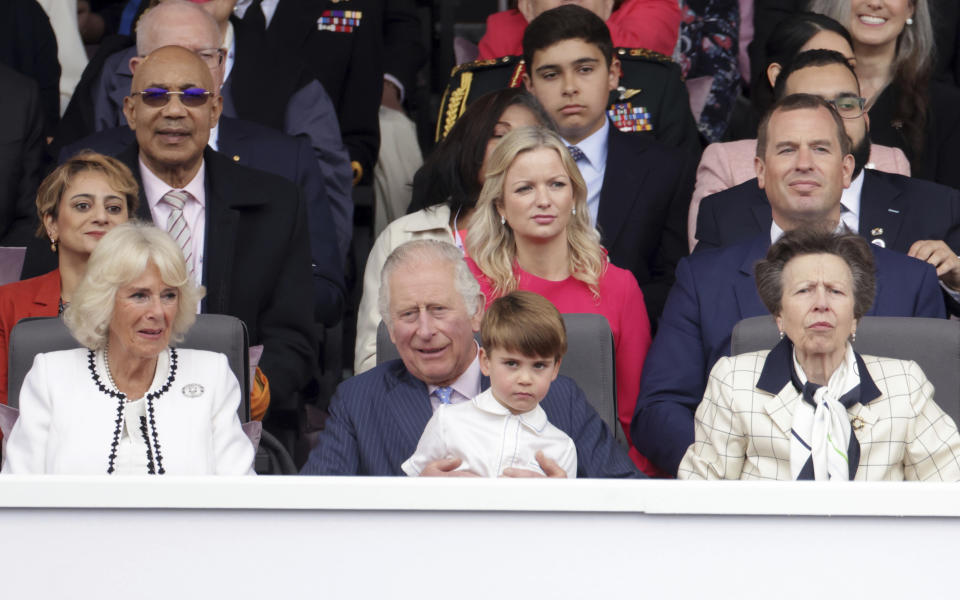 Prince Louis sits on Prince Charles' lap, with Camilla, Duchess of Cornwall at left and Princess Anne at right, during the Platinum Jubilee Pageant outside Buckingham Palace in London, Sunday June 5, 2022, on the last of four days of celebrations to mark the Platinum Jubilee. The pageant will be a carnival procession up The Mall featuring giant puppets and celebrities that will depict key moments from Queen Elizabeth II’s seven decades on the throne. (Chris Jackson/Pool Photo via AP)