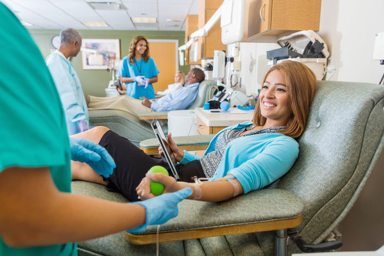 woman donating blood in busy donation center