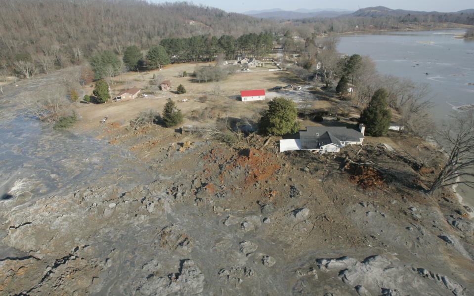 FILE - Homes that were destroyed by coal ash when a retention pond wall collapsed are shown at the TVA Kingston Fossil Plant on Dec. 22, 2008, in Harriman, Tenn. Attorneys for a group of workers who believe their jobs cleaning up a massive coal ash spill in Tennessee led to a slew of illnesses, including fatal cancers, have reached a settlement with the contractor who organized the cleanup for the Tennessee Valley Authority, according to a notice posted on the Jacobs Engineering website on Tuesday, May 23, 2023. (AP Photo/Wade Payne, File)