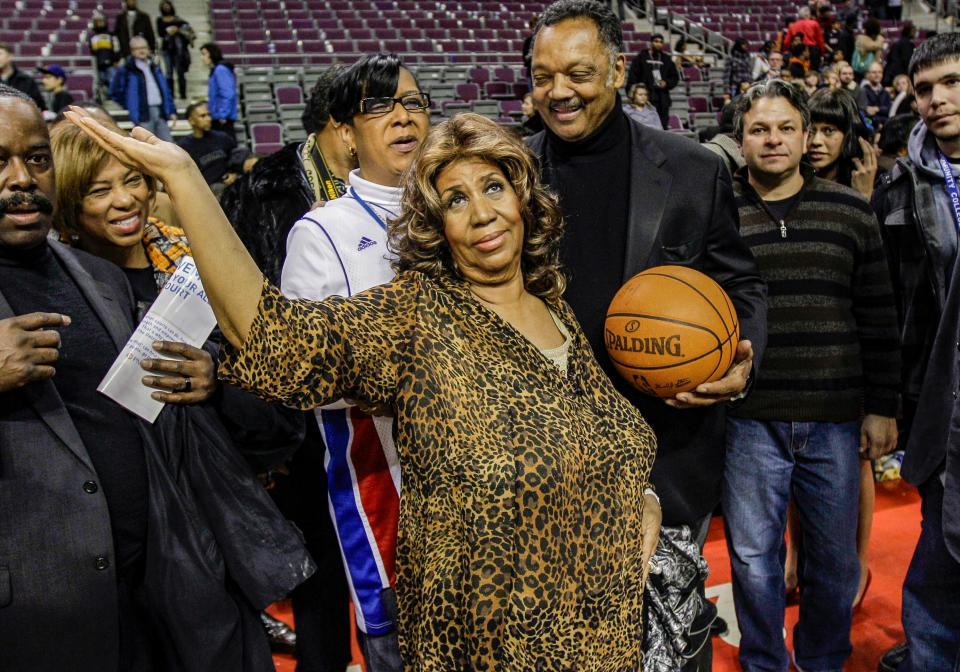 Aretha Franklin walks on the court with Jesse Jackson after the Detroit Pistons-Miami Heat NBA basketball game in Auburn Hills, Mich., Friday, Feb. 11, 2011. (AP Photo/Paul Sancya)
