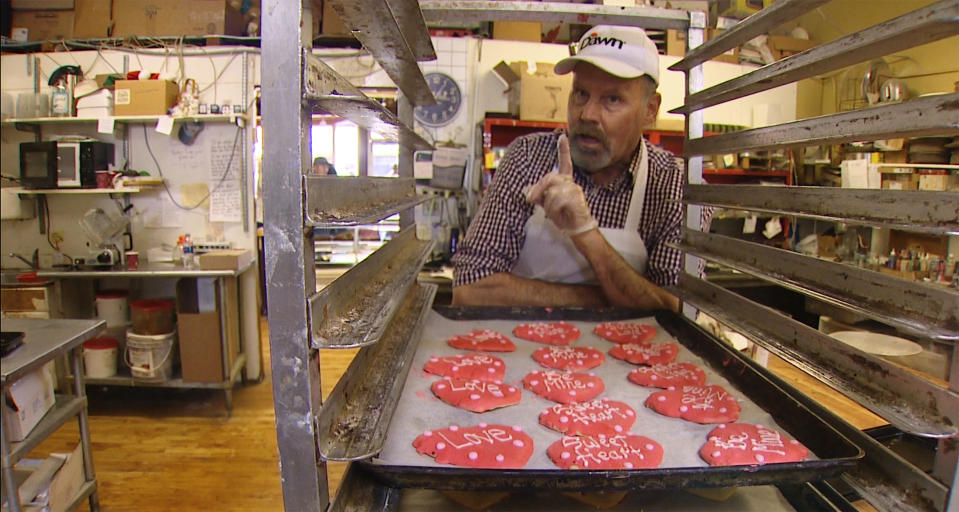 In this Thursday, Jan. 24, 2019, video image provided by KING-TV, baker Ken Bellingham, who owns Edmonds Bakery, speaks during an interview at his shop in Edmonds, Wash. Bellingham is apologizing for a politically charged Valentine's Day cookie that generated an uproar on social media. KING-TV reports that Bellingham has gotten phone calls from frustrated customers about the heart-shaped cookie with "Build that Wall" in frosting letters. The wall refers to President Donald Trump's signature campaign promise to build a southern-border wall. (KING-TV via AP)