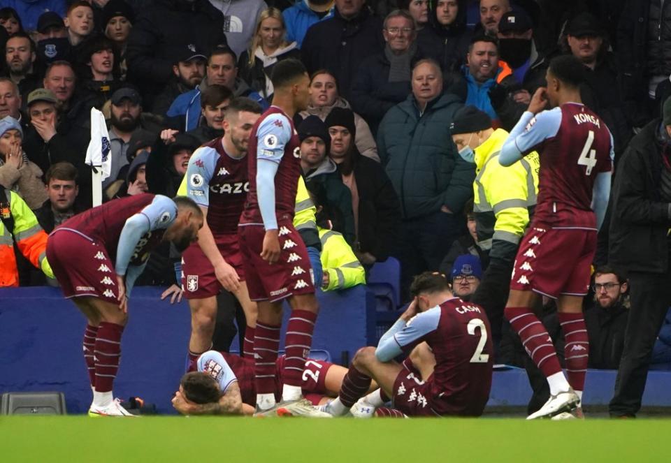 Aston Villa’s Lucas Digne, lying down, and Matty Cash, sitting, were hit by objects thrown from the crowd in the game against Everton (PA) (PA Wire)