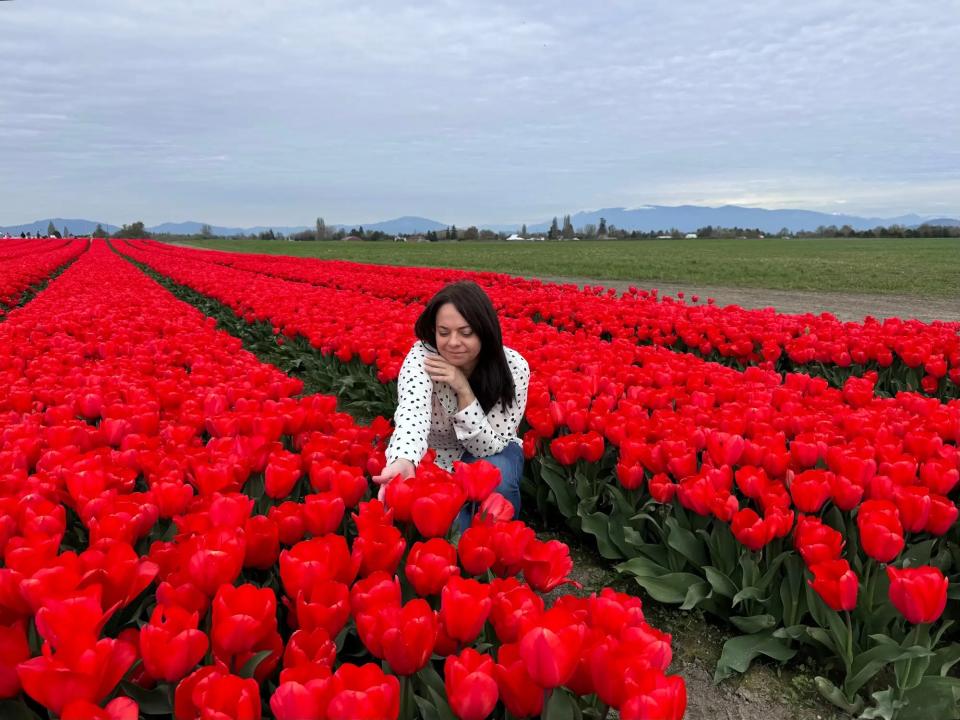 woman in a field of red flowers