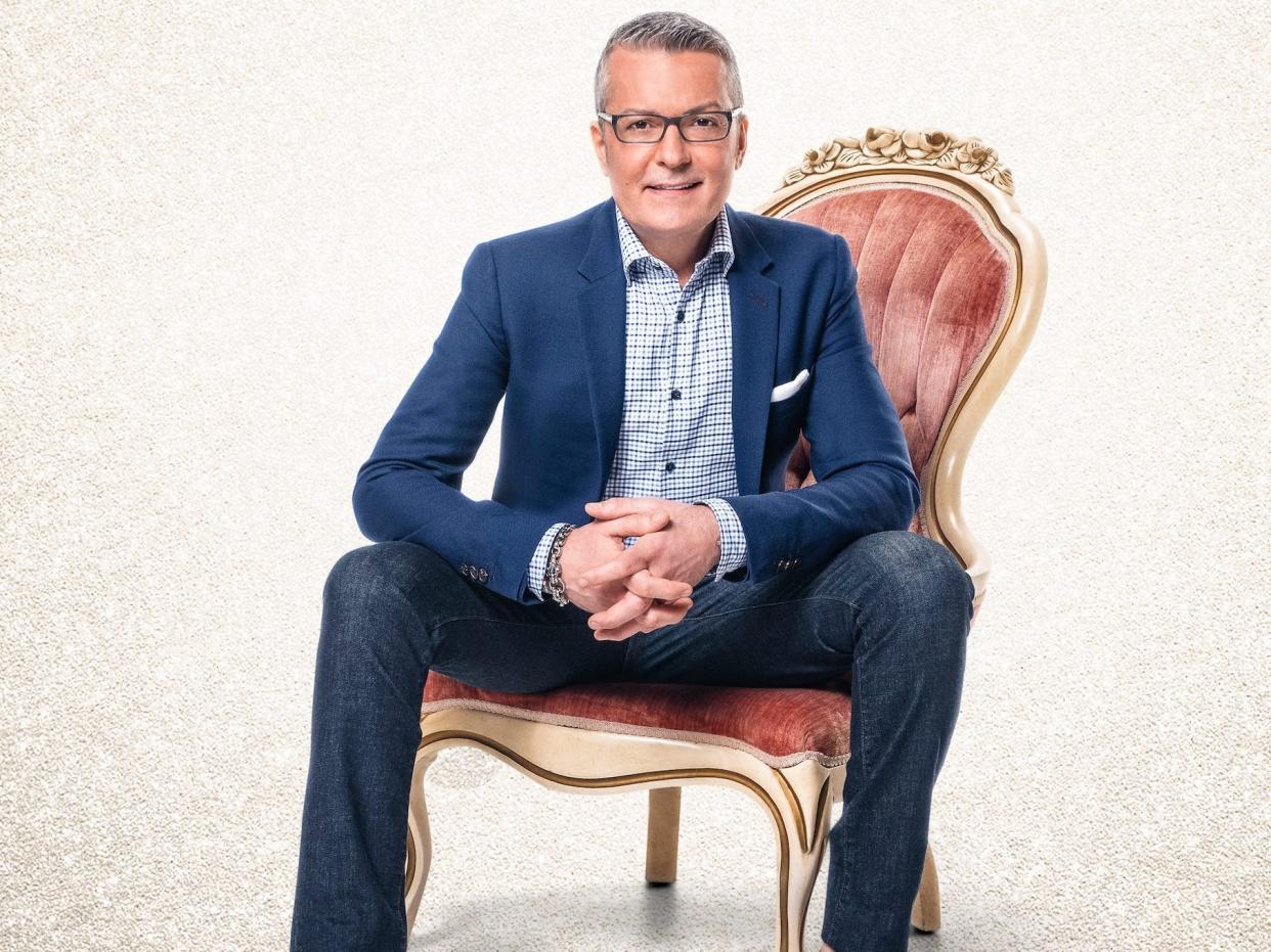 Randy Fenoli sits in a pink chair.