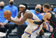 Oklahoma City Thunder's Lugeuntz Dort, left, looks to pass the ball under pressure from Toronto Raptors' Malachi Flynn, right, during the half of a basketball game Sunday, April 18, 2021, in St. Petersburg, Fla. (AP Photo/Steve Nesius)