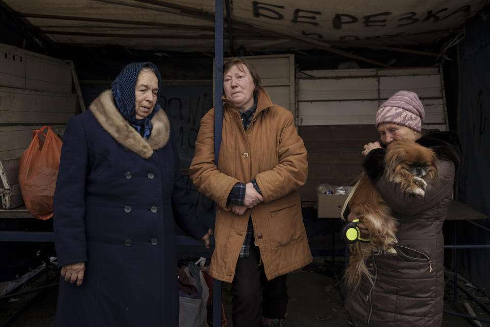 People fleeing the village of Ruska Lozova wait at a screening point in Kharkiv, Ukraine, Friday, April 29, 2022. Hundreds of residents have been evacuated to Kharkiv from the nearby village that had been under Russian occupation for more than a month. (AP Photo/Felipe Dana)