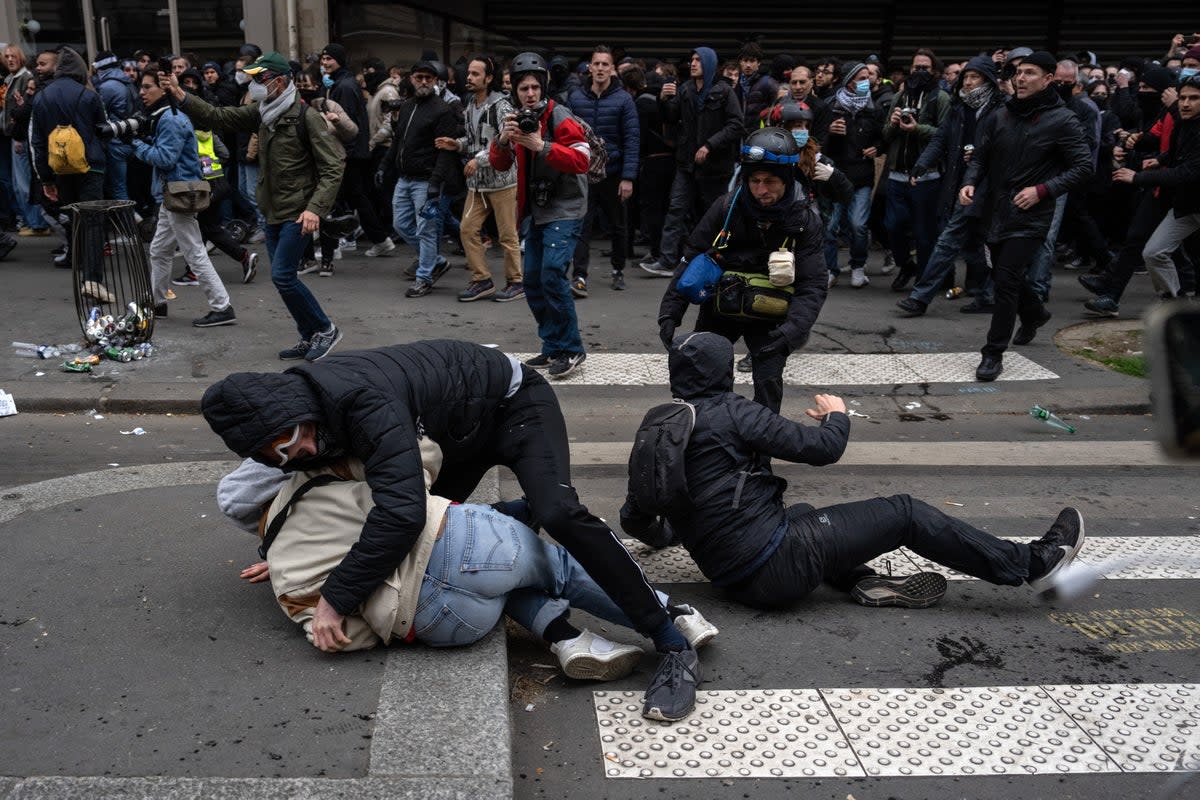 People fall over as police charge during proitests in Paris on Tuesday (Getty Images)