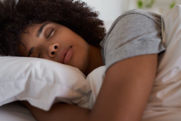 Close-up of a woman lying fast asleep in her bed.