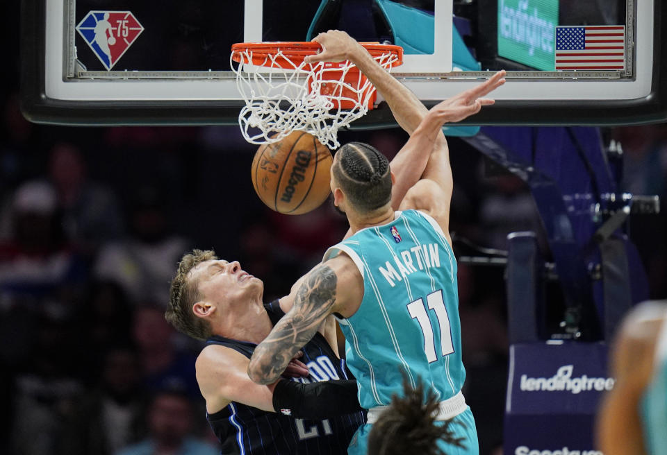 Charlotte Hornets forward Cody Martin, right, dunks over Orlando Magic center Moritz Wagner, left, during the first half of an NBA basketball game on Thursday, April 7, 2022, in Charlotte, N.C. (AP Photo/Rusty Jones)