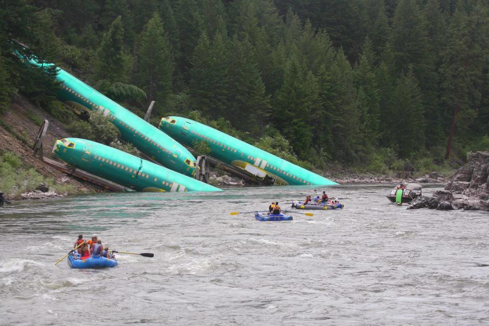 Three Boeing 737 fuselages lie on an embankment on the Clark Fork River after a BNSF Railway Co train derailed near Rivulet