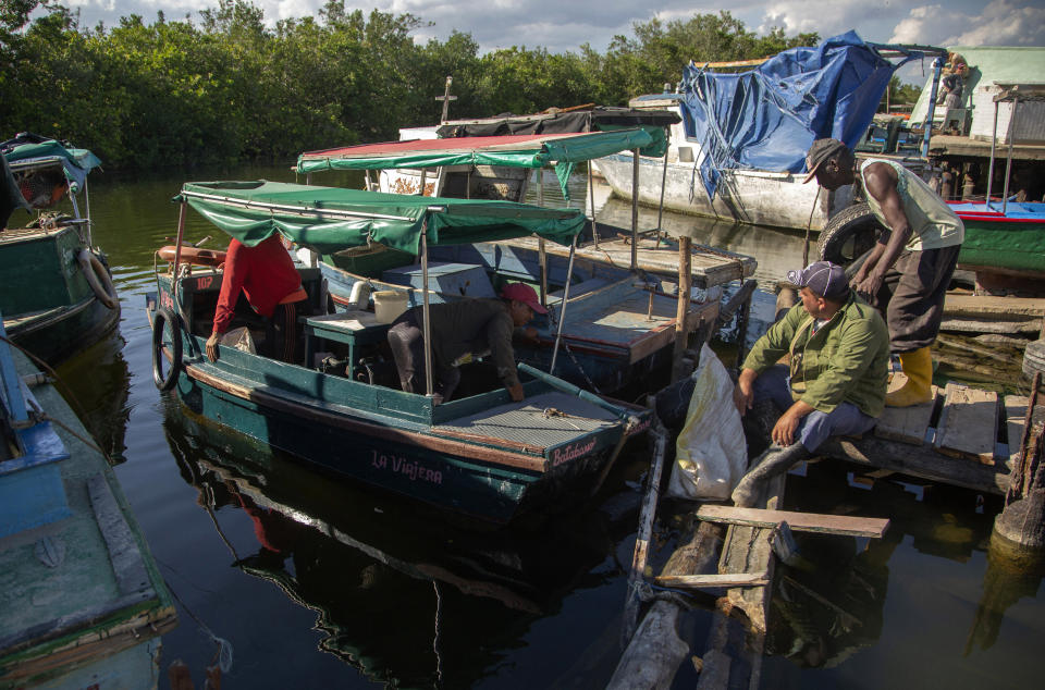 Several fishermen park their boats, after returning in Surgidero de Batabano, in Batabano, Cuba, Tuesday, Oct. 25, 2022. Cuba is suffering from longer droughts, warmer waters, more intense storms, and higher sea levels because of climate change. (AP Photo/Ismael Francisco)