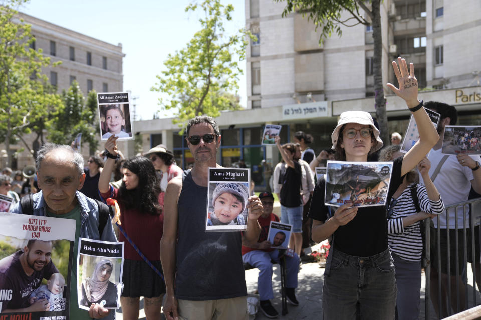 Activists chant slogans and hold pictures of hostages held in and Palestinians killed in the Gaza Strip as they call for a ceasefire, in the main square next to the official residence of Israeli Prime Minister Benjamin Netanyahu in Jerusalem, Friday, April 19, 2024. (AP Photo/Mahmoud Illean)