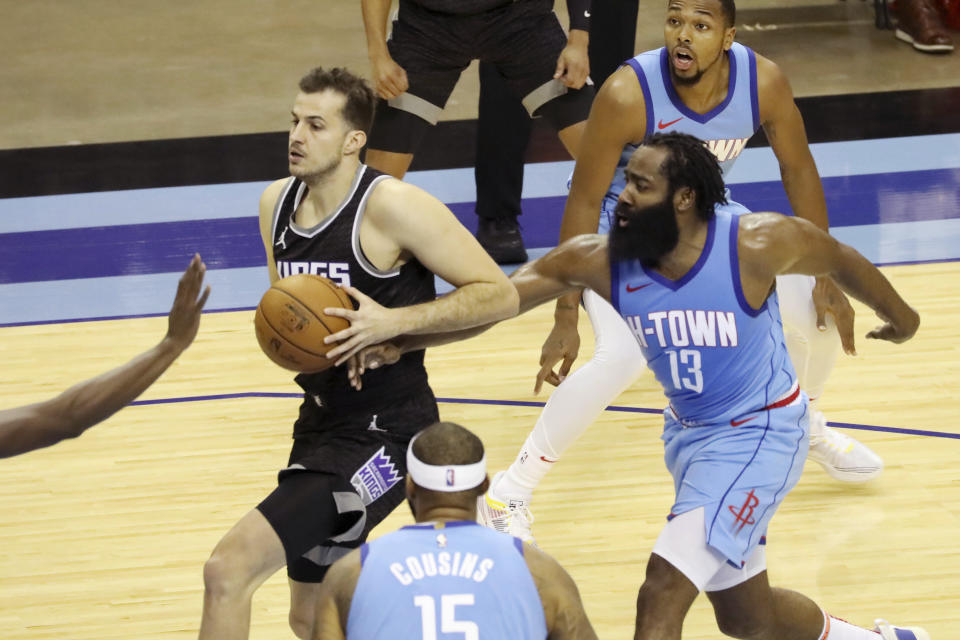 Houston Rockets guard James Harden reaches in against Sacramento Kings Nemanja Bjelica who goes to the basket during the first half of an NBA basketball game Thursday Dec. 31, 2020, in Houston. (AP Photo/Richard Carson)
