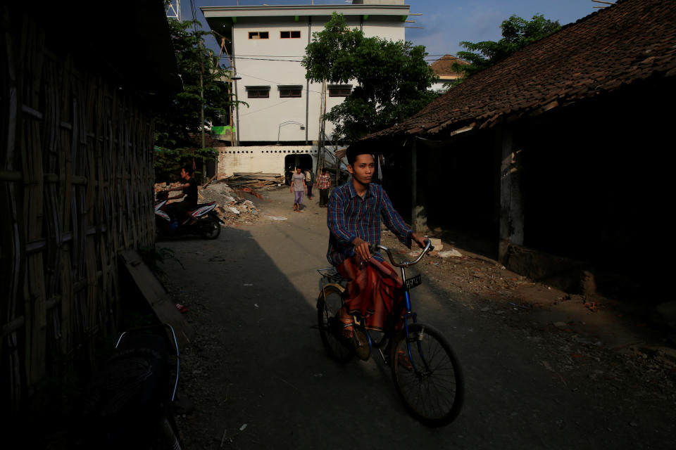 <p>A student rides a bicycle inside the grounds of Lirboyo Islamic boarding school in Kediri, Indonesia, May 19, 2018. (Photo: Beawiharta/Reuters) </p>