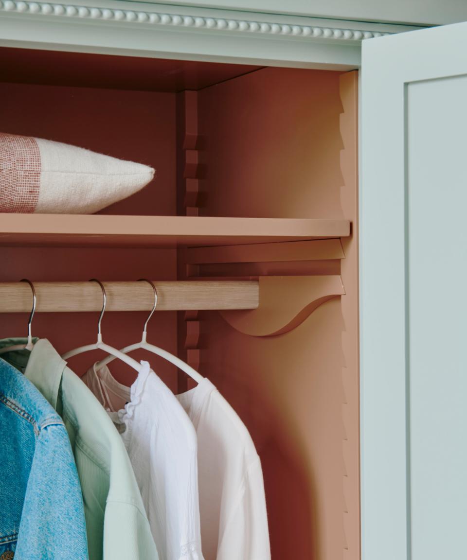 Closet with open door and clothes hanging inside