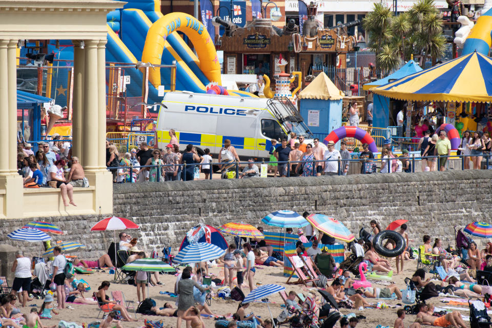 A police van oversees the promenade at Whitmore Bay, Barry Island, as sunseekers flock to the coast