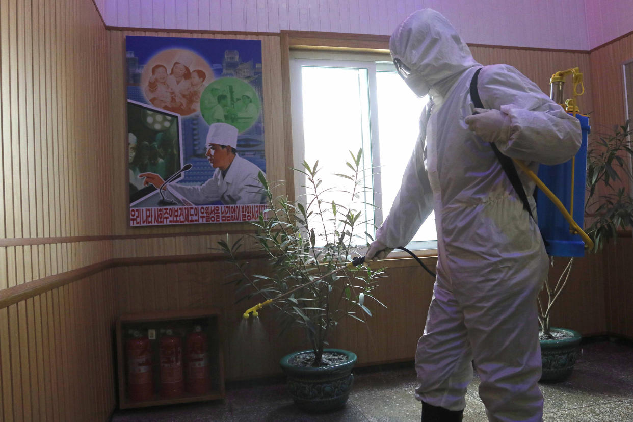 FILE- An official of the Hygienic and Anti-epidemic Center in Phyongchon District disinfect the corridor of a building in Pyongyang, North Korea, on Feb. 5, 2021. The Korean Central News Agency said Thursday, May 12, 2022, tests from an unspecified number of people in the capital Pyongyang confirmed that they were infected with the omicron variant. (AP Photo/Jon Chol Jin, File)