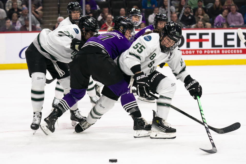 Boston forward Samantha Isbell (55) vies for the puck during a tangle with Minnesota players during the second period of Game 3 of the PWHL hockey championship series, Friday, May 24, 2024, in St. Paul, Minn. (Angelina Katsanis/Star Tribune via AP)