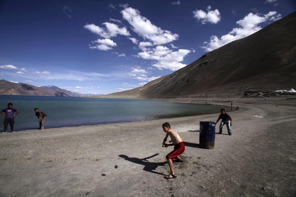 In this Friday, July 22, 2011, file photo, children play cricket by Pangong Lake, near the India-China border in Ladakh, India. India’s surprise move in August 2019, to carve out the sparsely populated region of Ladakh from the state of Jammu and Kashmir and make it into a territory directly controlled by New Delhi has been met with protests in Kargil, a Muslim-majority border city in Ladakh that identifies culturally with Kashmir, suggesting that the Hindu nationalist-led government’s plan to redraw the country’s political map will be far from easy. Mountainous Jammu and Kashmir comprises three regions: Hindu-majority Jammu, Muslim-majority Kashmir, and heavily Buddhist Ladakh. Ladakh borders Tibet to the east and the Chinese territory of Xinjiang in the far north. (AP Photo/Channi Anand, File)