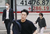 People walk near an electronic stock board showing Japan's Nikkei index at a securities firm Tuesday, July 16, 2024, in Tokyo. (AP Photo/Eugene Hoshiko)