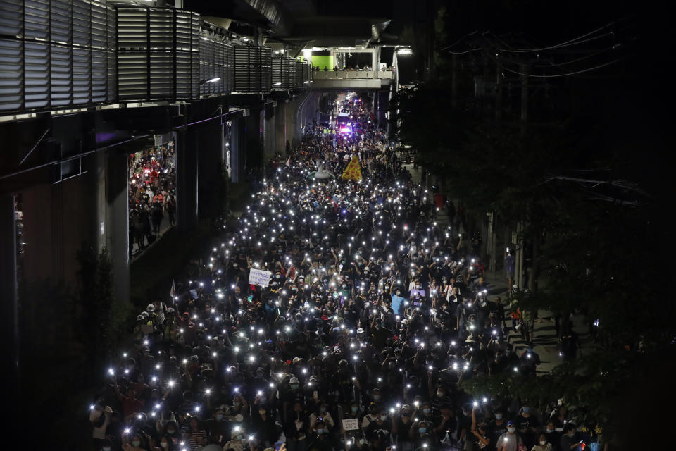 Protesters flash LED lights from their mobile phones while marching towards the base of the 11th Infantry Regiment,a palace security unit under direct command of the Thai king, Sunday, Nov. 29, 2020 in Bangkok, Thailand. Pro-democracy demonstrators are continuing their protests calling for the government to step down and reforms to the constitution and the monarchy, despite legal charges being filed against them and the possibility of violence from their opponents or a military crackdown. (AP Photo/Sakchai Lalit)