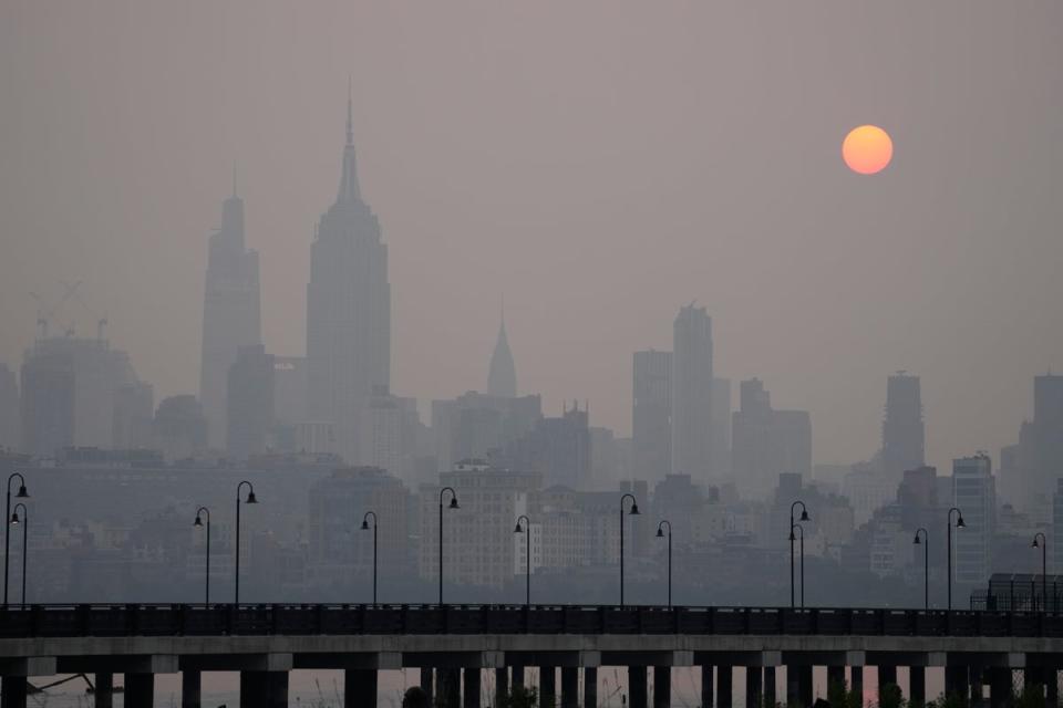 The sun rises over a hazy New York City skyline as seen from Jersey City on Wednesday (AP)