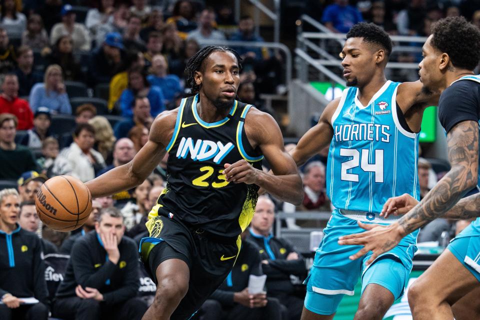 Dec 20, 2023; Indianapolis, Indiana, USA; Indiana Pacers forward Aaron Nesmith (23) dribbles the ball while Charlotte Hornets forward Brandon Miller (24) defends in the second half at Gainbridge Fieldhouse. Mandatory Credit: Trevor Ruszkowski-USA TODAY Sports