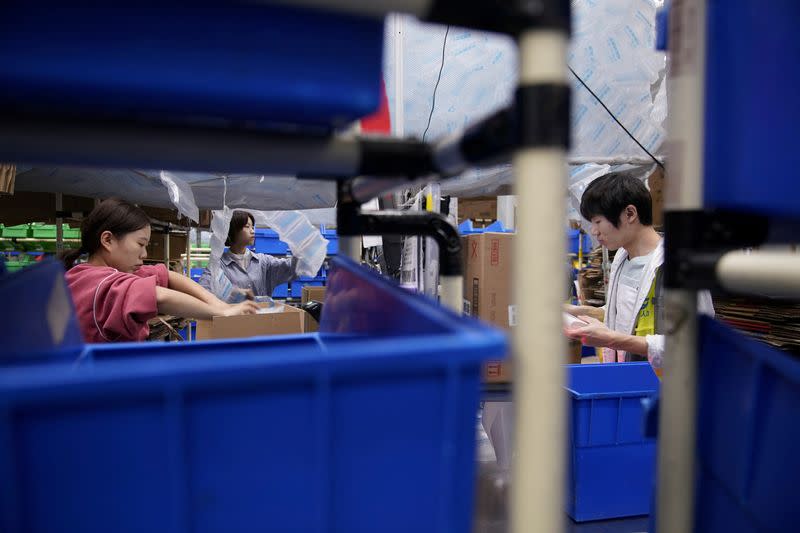 FILE PHOTO: Employees work at a warehouse of Cainiao, Alibaba's logistics unit in Wuxi