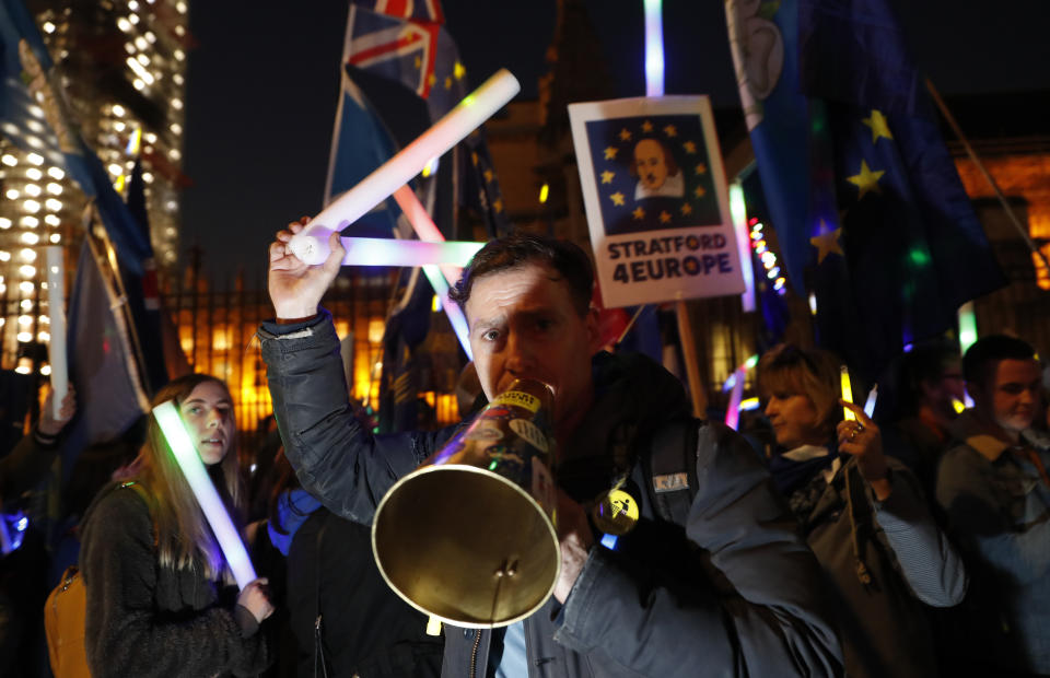 Remain in the European Union demonstrators use a megaphone outside the Palace of Westminster in London, Wednesday, Feb. 27, 2019. British Prime Minister Theresa May says she will give British lawmakers a choice of approving her divorce agreement, leaving the EU March 29 without a deal or asking to delay Brexit by up to three months. (AP Photo/Alastair Grant)