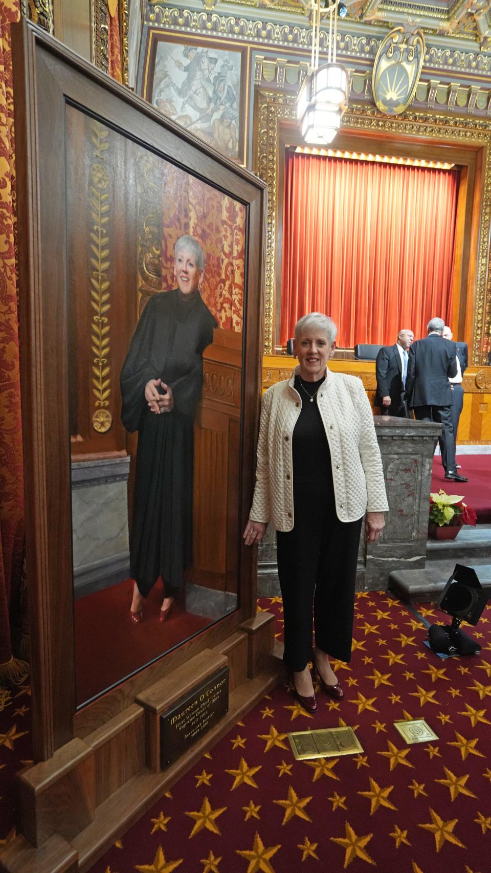 Maureen O'Connor poses next to her portrait after the dedication ceremony at the Thomas J. Moyer Ohio Judicial Center.