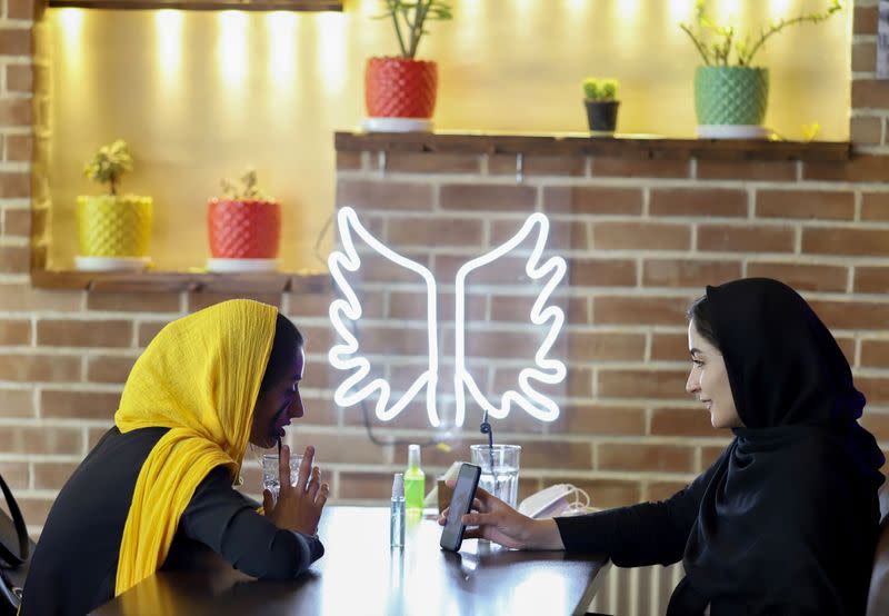 Iranian women sit in a cafe after the launching of the "Hamdam" dating app, in Tehran
