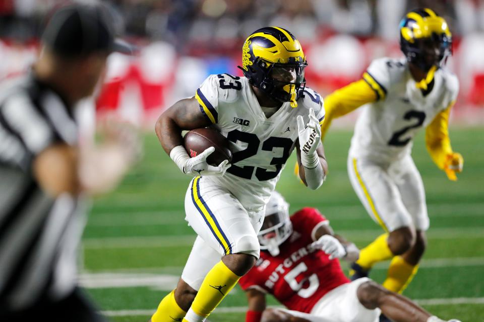 Michigan linebacker Michael Barrett (23) returns an interception against Rutgers during the second half of an NCAA college football game, Saturday, Nov. 5, 2022 in Piscataway, N.J. (AP Photo/Noah K. Murray)