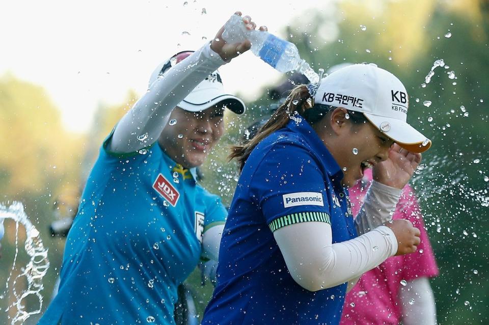 Meena Lee (left) sprays water on Inbee Park after Park defeated Brittany Lincicome on the first playoff hole during the 2014 Wegmans LPGA Championship.