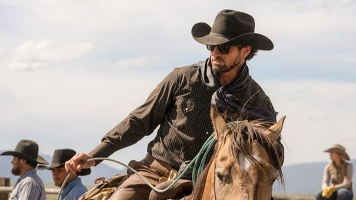 A cowboy rides a horse in Yellowstone.