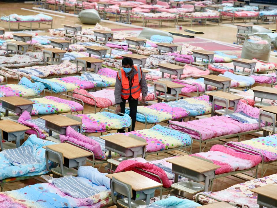 A worker sets up beds at the Hongshan Stadium to convert it into a makeshift hospital following an outbreak of the new coronavirus, in Wuhan, Hubei province, China February 4, 2020.