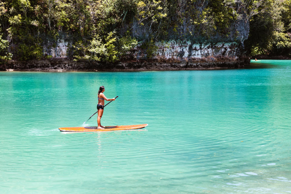 Beautiful woman practising stand up paddling, Siargao, Philippines as Cebu Pacific drops flights from Australia to $139