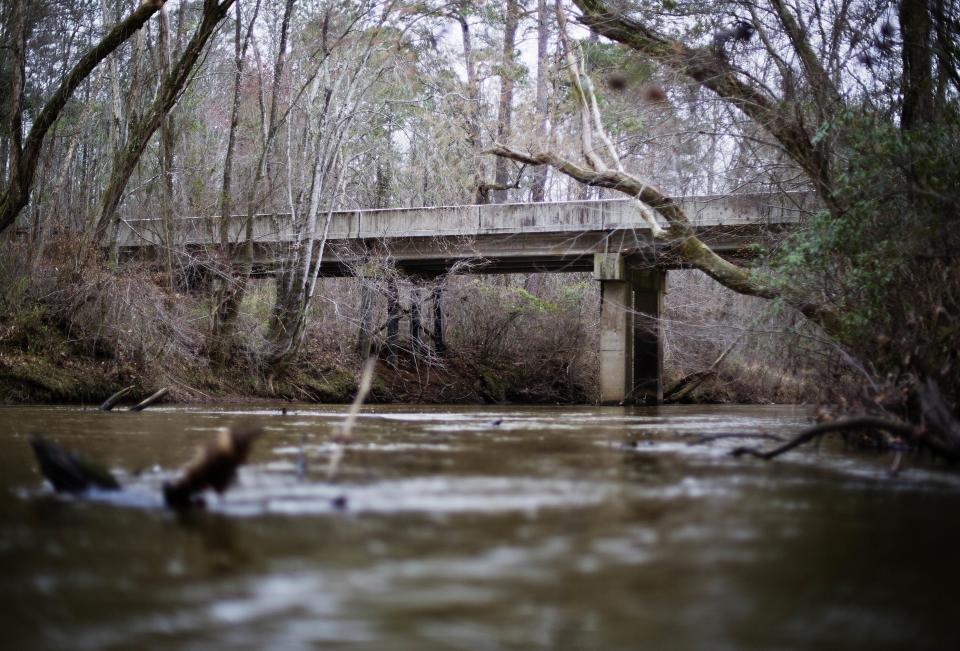 FILE- This Feb. 22, 2018, file photo shows a bridge that spans the Apalachee River at Moore's Ford Road where in 1946 two young black couples were stopped by a white mob who dragged them to the riverbank and shot them multiple times in Monroe, Ga. The gruesome lynching is prompting a U.S. court to consider whether federal judges can order grand jury records unsealed in old cases with historical significance. (AP Photo/David Goldman, File)