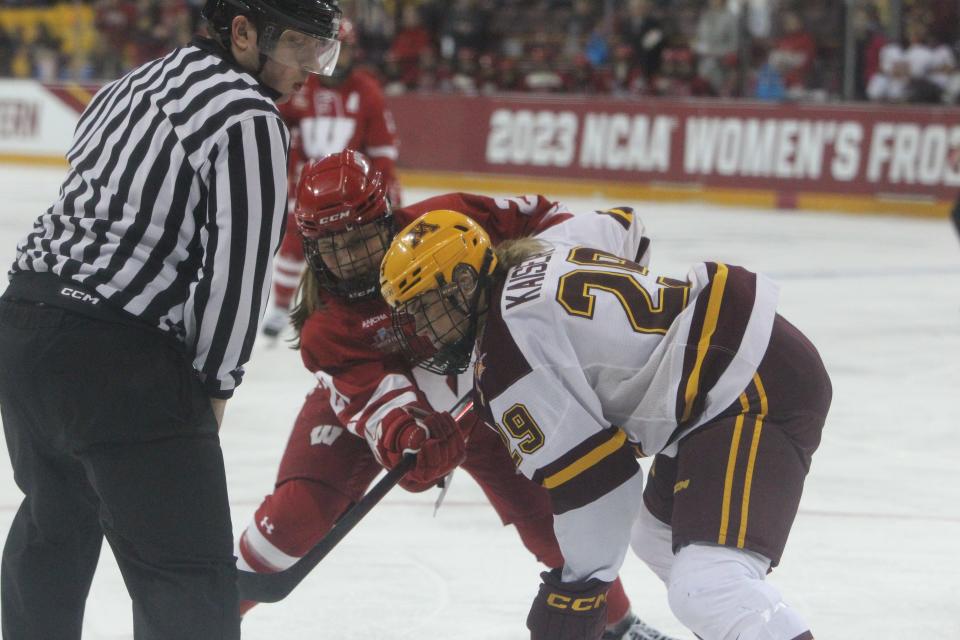 Wisconsin's Kirsten Simms (27) and Minnesota's Madison Kaiser (29) fight for the puck after a faceoff during the teams' national semifinal at AMSOIL Arena in Duluth, Minnesota on March 17, 2023. Both players will be in action when the Badgers and Gophers resume their rivalry Friday and Saturday at La Bahn Arena in Madison, Wisconsin.