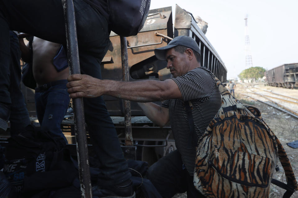 A Central American migrant climbs on a freight train on is way to the U.S.-Mexico border, in Ixtepec, Oaxaca state, Mexico, Tuesday, April 23, 2019. The train known in Spanish as "La Bestia" has carried migrants north for decades, despite its notorious dangers. People have died or lost limbs falling from the train. (AP Photo/Moises Castillo)