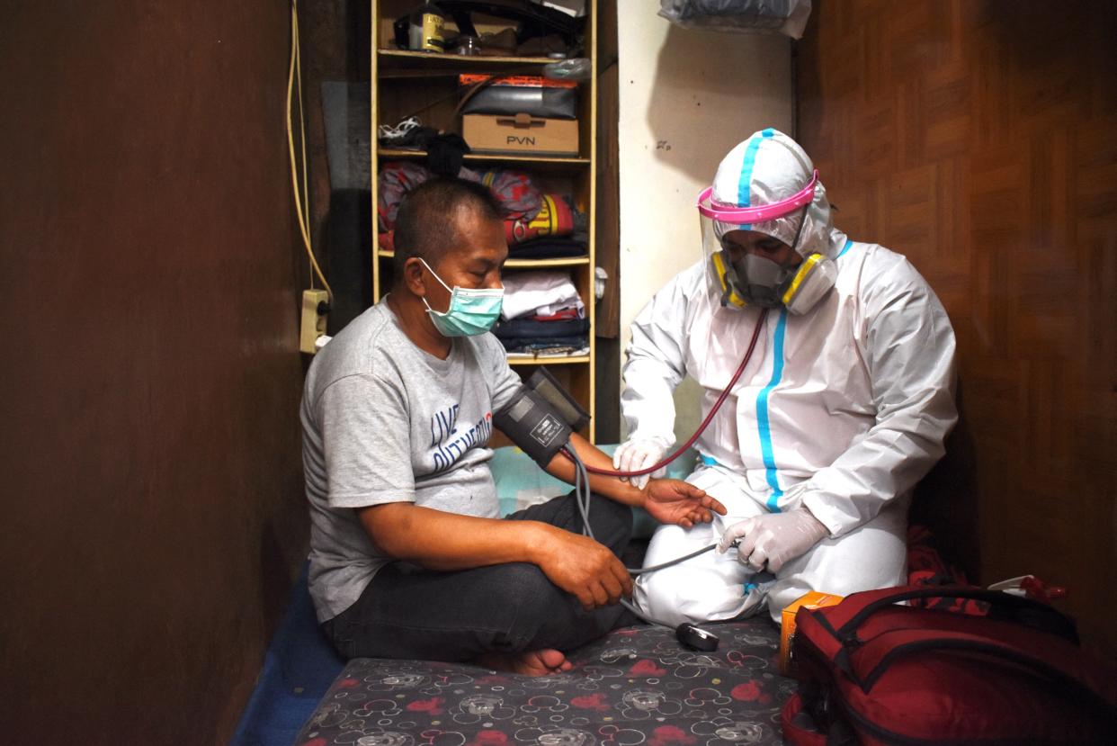 A health worker checks on a resident that is self isolating during the Covid-19 coronavirus pandermic at home in Bandung on August 4, 2021.